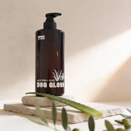 Black bottle of Dog Gloss with aloe vera and olive on a neutral background