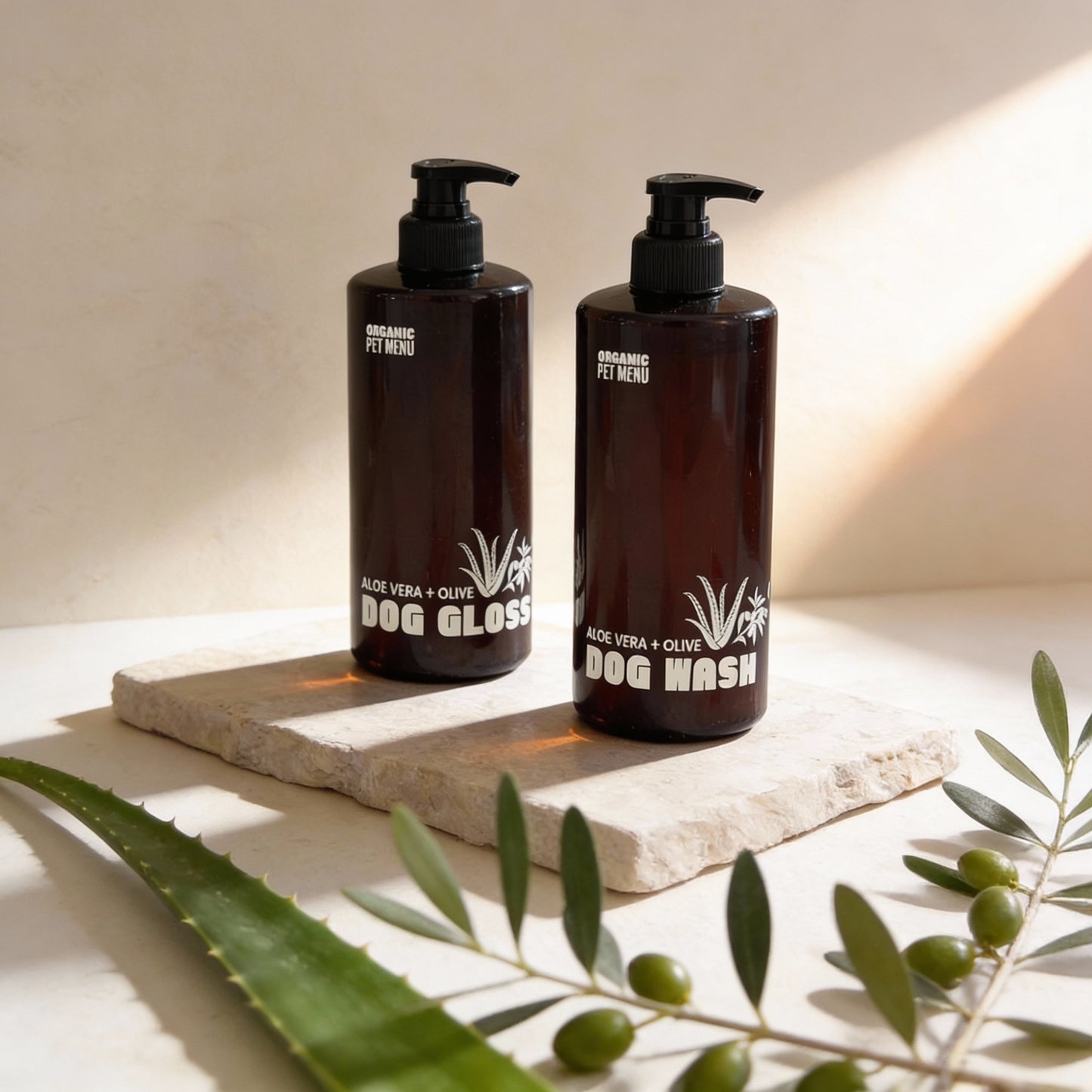 Two bottles of organic pet shampoo on a stone surface with green leaves.