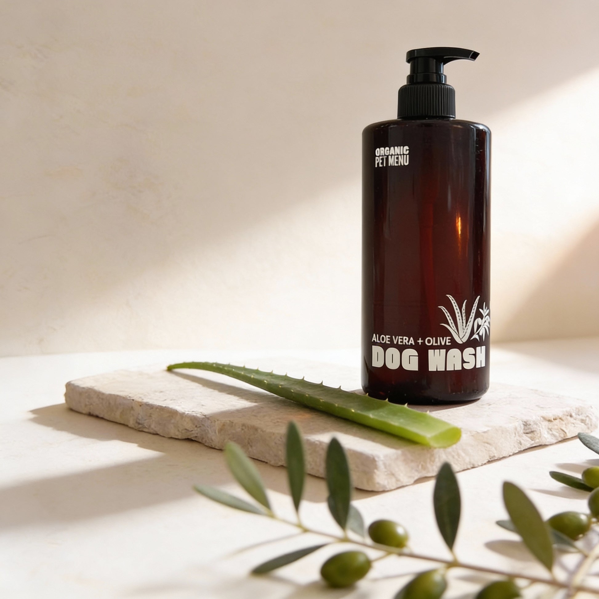 Brown bottle of dog wash with aloe vera and olive on a light background